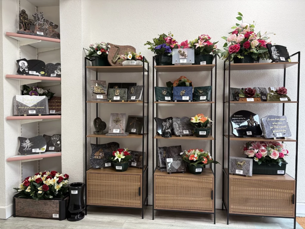 Présentoir de plaques funéraires personnalisées et compositions florales en magasin.